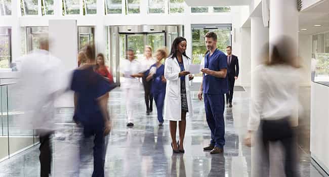 healthcare professionals discuss a real estate proposal in a busy medical lobby